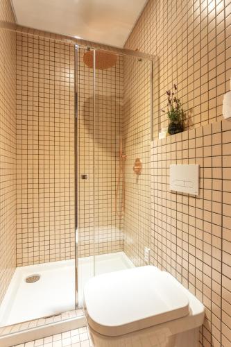 a bathroom with a shower and a toilet and a tub at Casas da Formosa - Downtown Alegria in Tavira