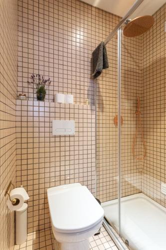 a bathroom with a toilet and a shower and a tub at Casas da Formosa - Downtown Alegria in Tavira