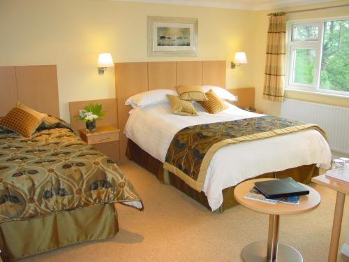 a hotel room with two beds and a table at Lingwood Lodge in Bowness-on-Windermere