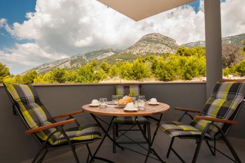a table and chairs on a balcony with a view of mountains at Apartments Mistral in Bol
