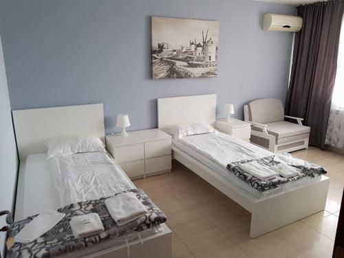 a bedroom with a bed and a chair at Family Hotel Gogov in Sinemorets