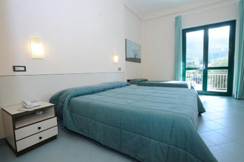 a bedroom with a large green bed and a window at L'Approdo di Angelino in Pizzolungo