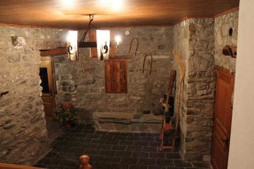 a room with a stone wall with a guitar in it at Turismo Rural Casa Sastre in Forcat