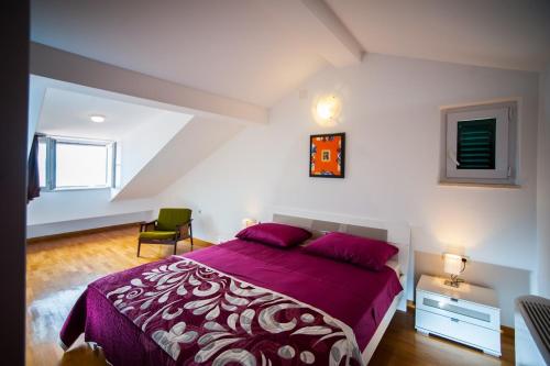 a bedroom with a purple bed and a chair at House Koloc in Bol
