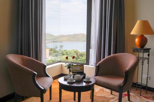 a room with two chairs and a table and a window at Saigon Quy Nhon Hotel in Quy Nhon
