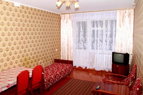 - une chambre avec un lit, une télévision et une fenêtre dans l'établissement Prime Home 4, à Tchernihiv