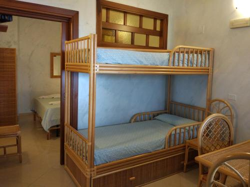 ニコーテラ・マリーナにあるAgriturismo Cally Callyの二段ベッド2組(鏡付)が備わる客室です。