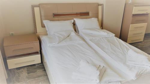 two beds in a room with white sheets and pillows at Хотел "АВЕНЮ" in Stara Zagora