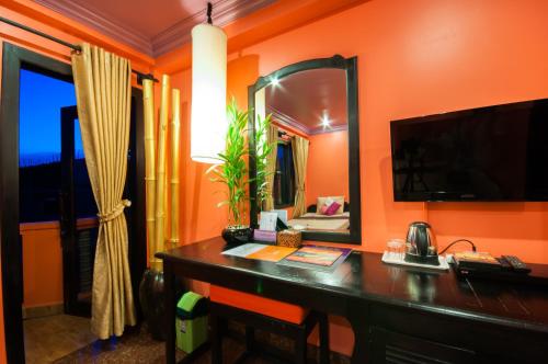 Camera con scrivania, specchio e TV. di Golden Butterfly Villa a Siem Reap