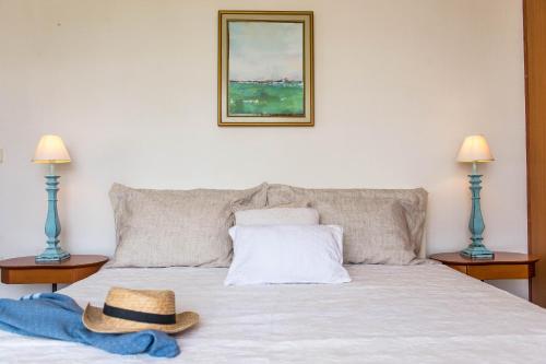 ein Bett mit zwei Lampen und zwei Hüten darauf in der Unterkunft Eirinaki House in Patmos