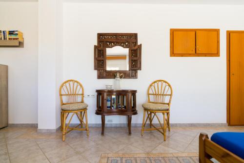 a table and two chairs and a mirror on a wall at Aris Palace in Elia
