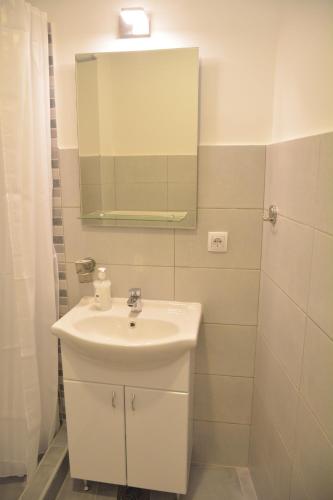 a bathroom with a white sink and a mirror at Vila Nova in Niš