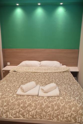 a bedroom with a bed with two towels on it at Vila Nova in Niš