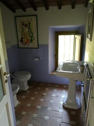 a bathroom with a white sink and a toilet at Torre Di Sant'Ansano in Corsano