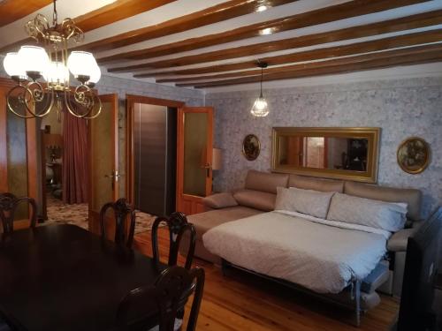 a living room with a bed and a dining room table at Alojamiento Santa Engracia Laguardia in Laguardia