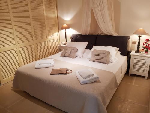 a bedroom with a large white bed with towels on it at Therme Sea Luxury Lodge in Thermisia