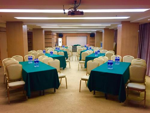 a room with green tables and chairs with blue glasses on them at Slowcom┃Yuebei Hotel （Guangzhou Provincial Government) in Guangzhou