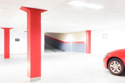 a red car parked inside of a parking garage at Feel Belgrade Apartments in Belgrade