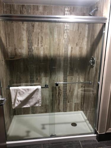 a shower with a glass door in a bathroom at The Lincoln Hotel Philadelphia in Trevose