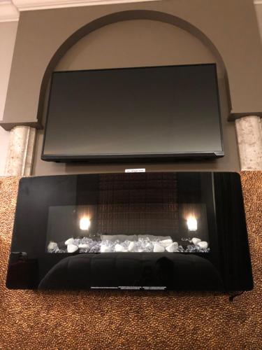 a black table with two candles in front of a tv at The Lincoln Hotel Philadelphia in Trevose