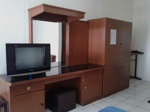 a wooden entertainment center with a television on top of it at Parama Hotel in Wonosobo