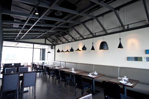 a restaurant with tables and chairs in a room at Hotel Avenue in Changwon