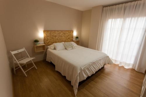 モナチルにあるApartamento Monachil Puebloのベッドルーム1室(ベッド1台、椅子、窓付)