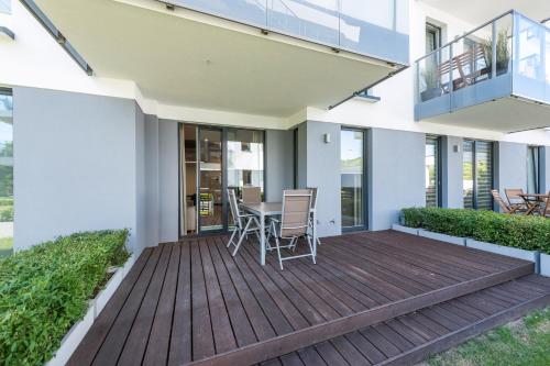 a deck with a table and chairs on a house at INA Rent - Tre Mare Apartamenty in Gdańsk