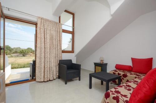 a bedroom with a red bed and a window at Infinity Apartments in Naxos Chora