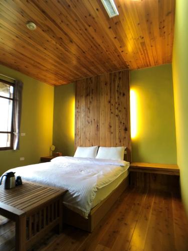 a bedroom with a large bed with a wooden ceiling at Jiji Village Villa B&B in Lugu Lake