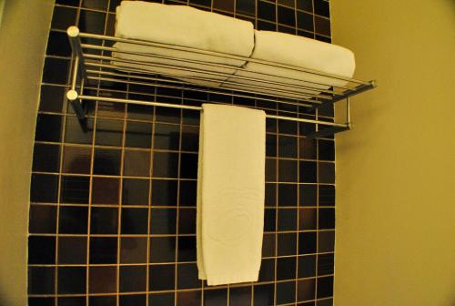 a towel rack with towels on a black tiled wall at Hotel Elizabeth Cebu in Cebu City