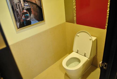 a bathroom with a toilet with a picture on the wall at Hotel Elizabeth Cebu in Cebu City