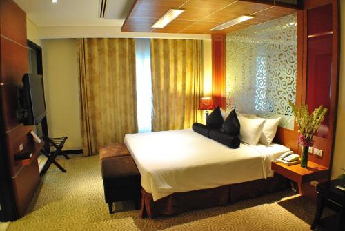 a hotel room with a bed and a television at Hotel Elizabeth Cebu in Cebu City