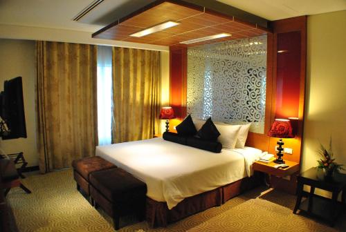a hotel room with a large bed and a window at Hotel Elizabeth Cebu in Cebu City