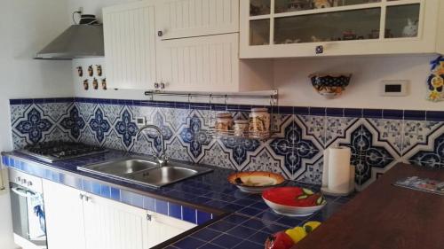 a kitchen with a sink and blue tiles on the counter at Casa Testa in Formia