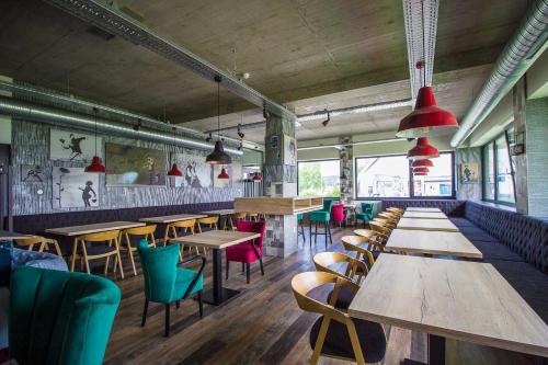 a restaurant with wooden tables and colorful chairs at HOTEL 63 in Poprad