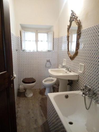 a bathroom with a sink and a toilet and a mirror at Torre rossa in Bolgheri