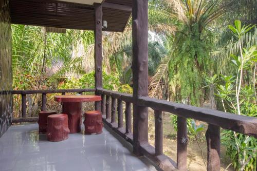 a porch of a house with a table and stools at Khao Sok Palmview Resort in Khao Sok