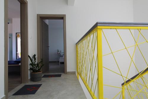 a hallway with a yellow and white wall at Narancin Apartments in Trogir