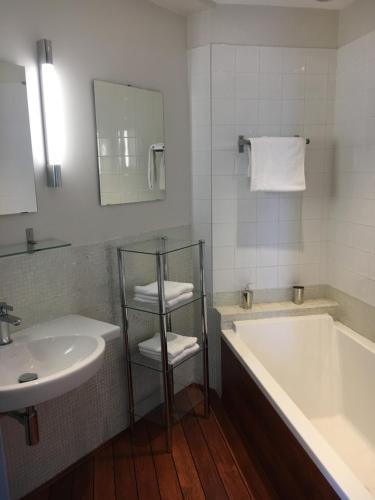 une salle de bain avec une baignoire et un lavabo et une baignoire dans l'établissement Appartement Le Palais Des Iles, à Cannes