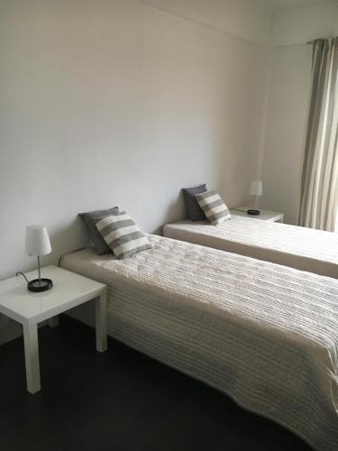 - 2 lits dans une pièce avec une table dans l'établissement Appartement Le Palais Des Iles, à Cannes