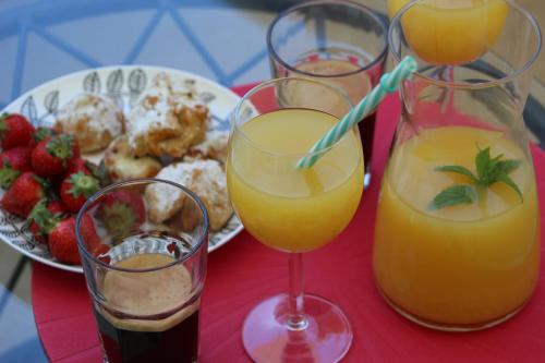three glasses of orange juice and a plate of food at Narancin Apartments in Trogir
