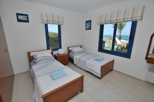 A bed or beds in a room at Kymmates Beach Front Villas