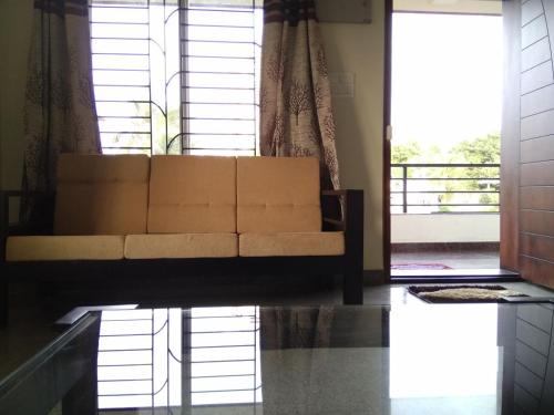 a living room with a couch in front of a window at Aikya in Mangalore