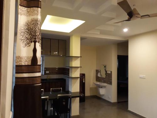 a room with a kitchen with a ceiling fan at Aikya in Mangalore