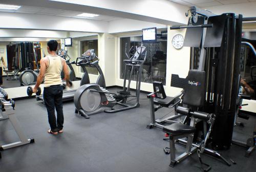 a man walking through a gym with weights at Hotel Elizabeth Cebu in Cebu City