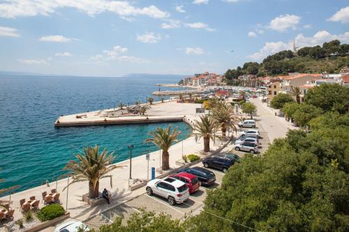 a group of cars parked in a parking lot next to the water at Waterfront Roko in Podgora