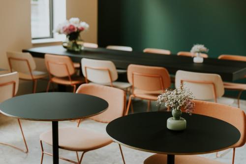 una sala de reuniones con mesas, sillas y flores en Hotel Jerom, en Kalmthout