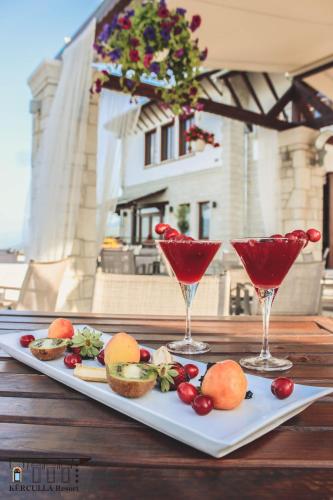 two plates of food and two wine glasses on a table at KERCULLA Resort in Gjirokastër