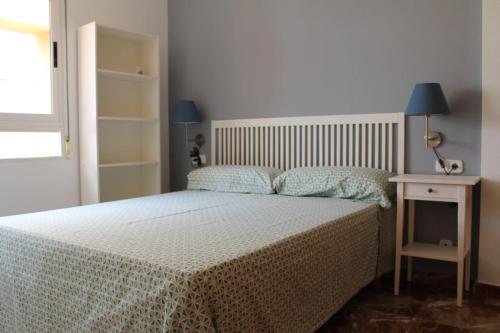 a bedroom with a bed and a table with a lamp at Atico centro Alicante in Alicante